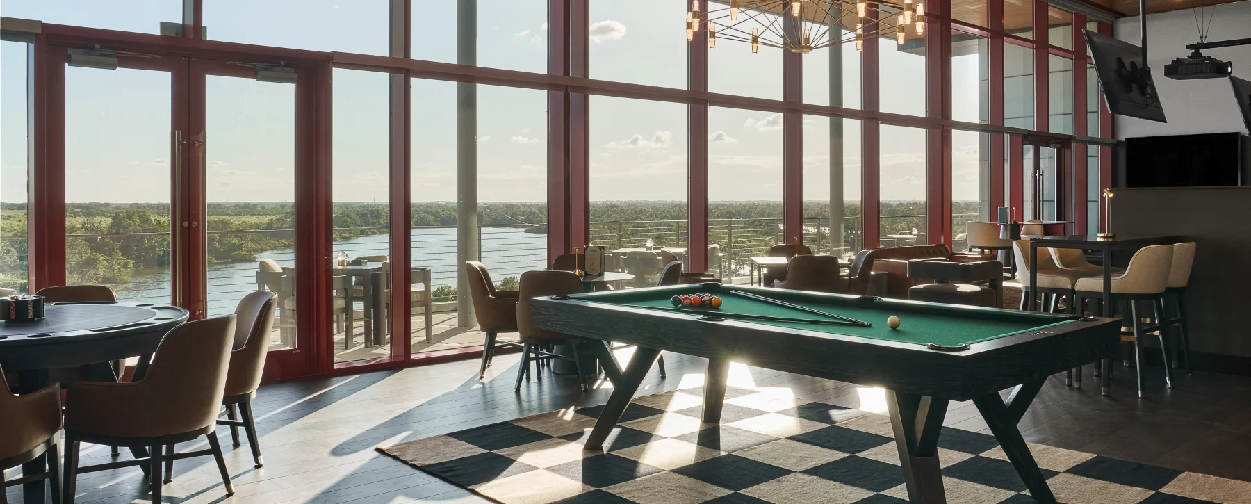Lakeside lounge with a billiards table and floor-to-ceiling windows